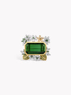 Gold ring featuring rectangular green tourmaline center with diamond halo and side motifs