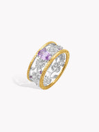 Openwork diamond ring with brushed band, gold bezel and purple oval stone, angled view