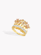 Gold-tone ring with pink sapphire flower clusters and white accent stones