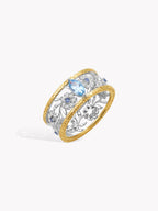 Two-tone openwork diamond daisy ring with brushed gold band and blue center stone