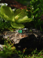 Men’s emerald ring with rectangular green center stone and textured silver bezel