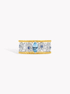 Openwork diamond daisy band ring with brushed gold edges and blue center stone