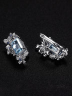 Silver floral halo earrings with light blue aquamarine-style center stones