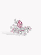 Pink diamond butterfly bloom ring with pear center and scattered floral stones.