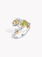 Silver gemstone ring with large green cushion center, clear diamonds and gold-tone curves