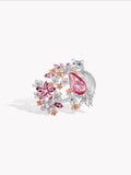 Silver-tone open ring with pink pear center stone and floral gem cluster