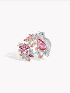 Silver-tone open ring with pink pear center stone and floral gem cluster