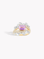 Twisted band ring with purple rectangular sapphire center and diamond pavé sides, angled