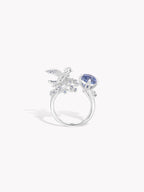 Open ring featuring a blue round sapphire-style stone and winged crystal motif