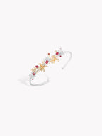 White gold bracelet with floral clusters of red, pink, and clear gemstones