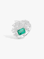 Emerald and diamond ring with green rectangular center stone and sculpted diamond wings
