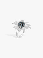 Sunflower gemstone ring with blue center and clear crystal petals, silver-tone band