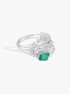 Emerald and diamond ring with green emerald center and prong-set stone cluster