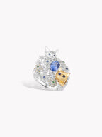 Cat garden sapphire ring with oval blue center stone, white metal, twin cat charms