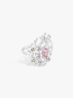 Oval pink gemstone floral ring with clear and colored stones set in white metal band