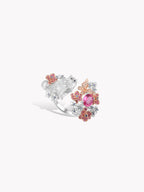 Silver ring with cat, butterfly, and floral clusters; pink oval gemstone on openwork band