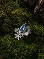 Aquamarine snowflake ring with oval blue gemstone and starburst snowflake halo settings