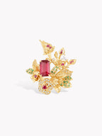 Gold-tone vine branch ring with maroon center gem, pink highlights, and green details