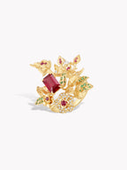 Gold-tone thorny branch ring with maroon center stone and pink, green accents