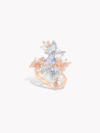 Rose gold sapphire ring with blue center stone and crystal pavé leaf setting