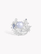 Starlit Siren Harp ring with silver setting, oval white cabochon, blue accents