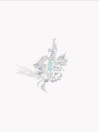 Silver-tone ring with teal teardrop gemstone and icy snowflake details