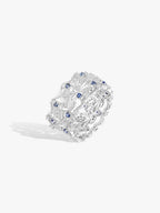 Ornate swan-wing ring with blue stones and white diamond accents in textured openwork setting