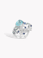 Silver ring with oval aqua center stone and blue gemstone accents