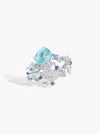 Silver statement ring with oval aqua center stone and blue clustered side stones