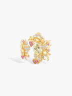 Gold open branch ring with floral clusters, central light green gemstone, pink and clear highlights