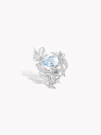 Silver-tone floral ring with oval blue gemstone and curved lily leaves