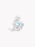 Silver lily flower ring with oval aquamarine-blue center stone and crystal details