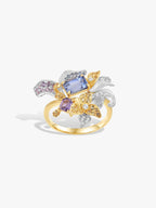 Gold iris gemstone ring with blue square center, purple stones, clear accents