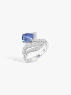 White gold ring with cushion-cut blue sapphire and wave diamond pavé band