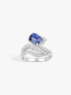 White gold ring with cushion-cut blue sapphire and diamond wave shank