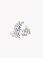 Floral branch ring detail view, blue oval center stone with clear gems and gold-toned leaves