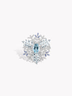 Snowflake twist ring with oval blue center stone, silver-toned icy halo
