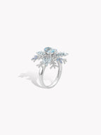 Snowflake twist ring angled view with oval blue center stone and bright icy accents
