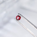Round ruby gemstone ring with prong-set red stone and pavé metal band