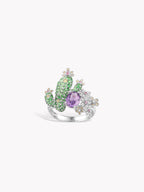 Cactus gemstone ring side view with purple oval center, green stones, and white accents