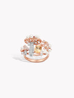 Rose gold-tone ring with pearls and a blue center stone, plus clear side gemstones