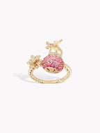Gold-tone gourd fortune ring with pink textured centerpiece and flower charms