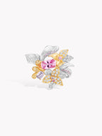 Floral iris ring with oval pink gemstone, clear accents, gold and silver leaf petals