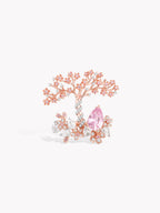 Rose gold tree-branch ring with pink oval center stone and clustered clear side stones