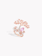 Rose gold tree-branch ring with pink oval sapphire and clear stone clusters on band