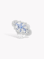 Sapphire blue hydrangea ring with oval center stone and pavé details on silver-toned band