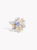 Silver and gold flower-style ring with oval blue center stone and clear glittering stones