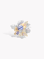 Silver and gold flower-style ring with oval blue center stone and clear glittering stones