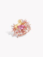 Gold-tone ring with pink oval gemstone and prong-set pink stone accents