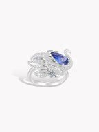 Swan sapphire ring front view with oval blue center stone and crystal pavé wings